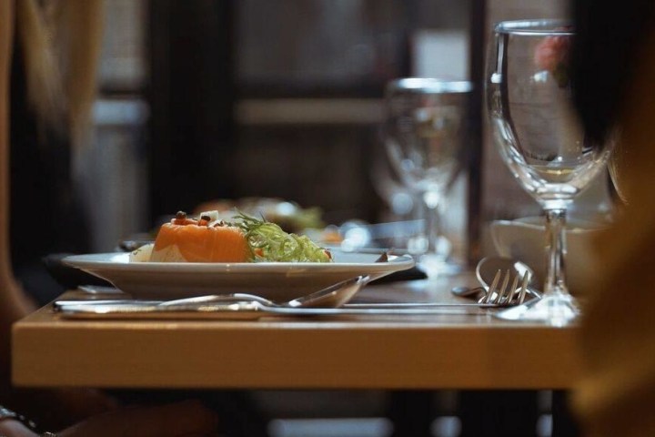 a person sitting at a table with wine glasses