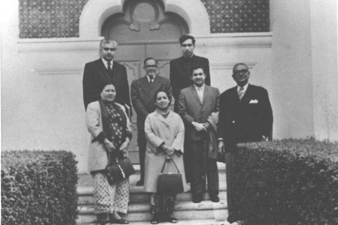 a group of people posing for a photo in front of a building