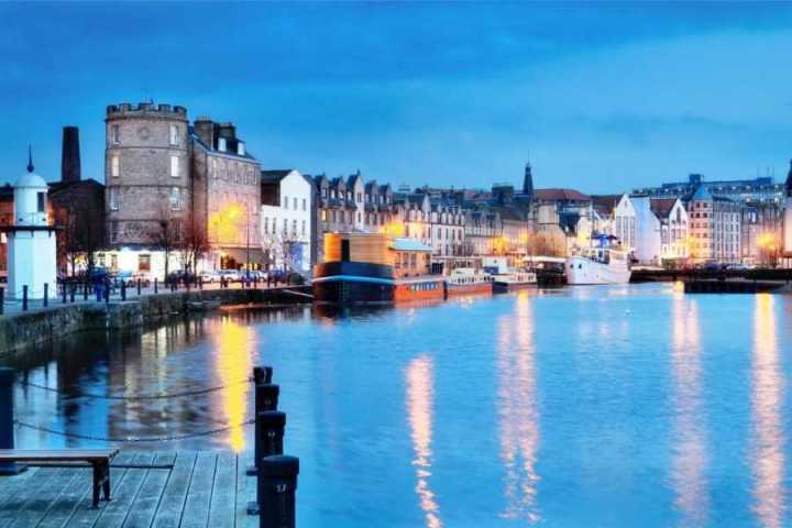 a bridge over a body of water with a city in the background