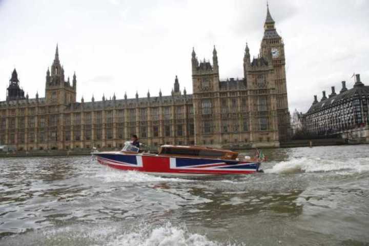 a boat in the water with Palace of Westminster in the background