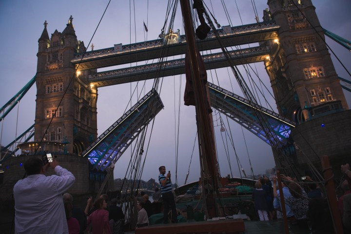 a group of people standing in front of a bridge