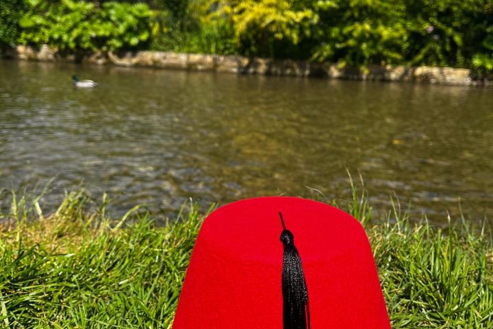 a colorful kite sitting on top of a grass covered field