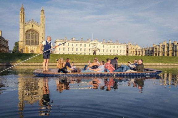 a group of people riding on the back of a boat in the water
