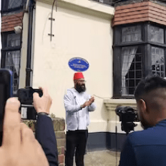 a person standing in front of a building talking on a cell phone