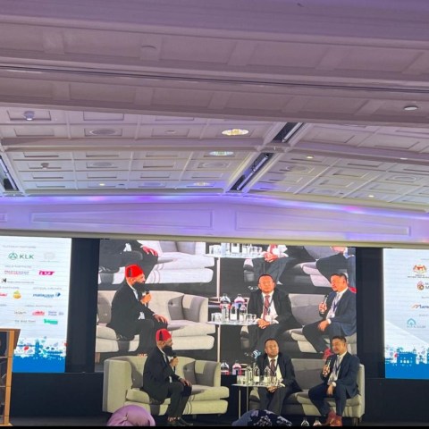 a group of people standing in front of a monitor