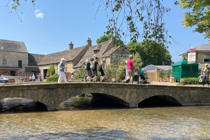 a group of people crossing a bridge over a river
