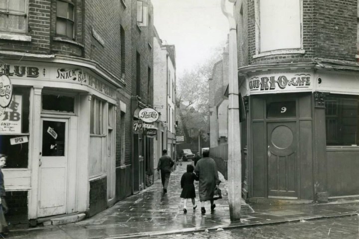 a group of people walking down a street holding an umbrella