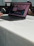 Open laptop on table, showing video call with people.
