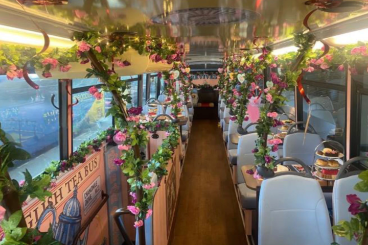 Bus interior with floral decorations and tables set for dining.