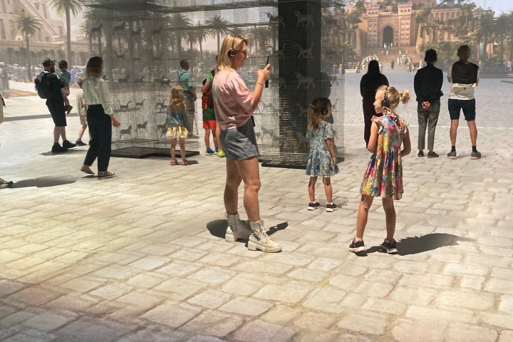 People viewing immersive digital wall projections in a room.